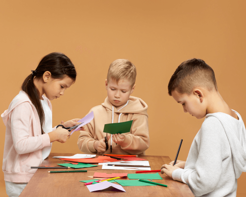 crianças a usar tesouras e a escrever